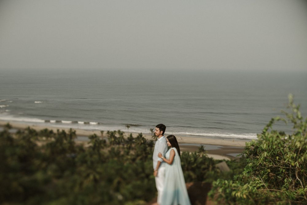 Coastal clifftop engagement photo with dramatic ocean view in the background.