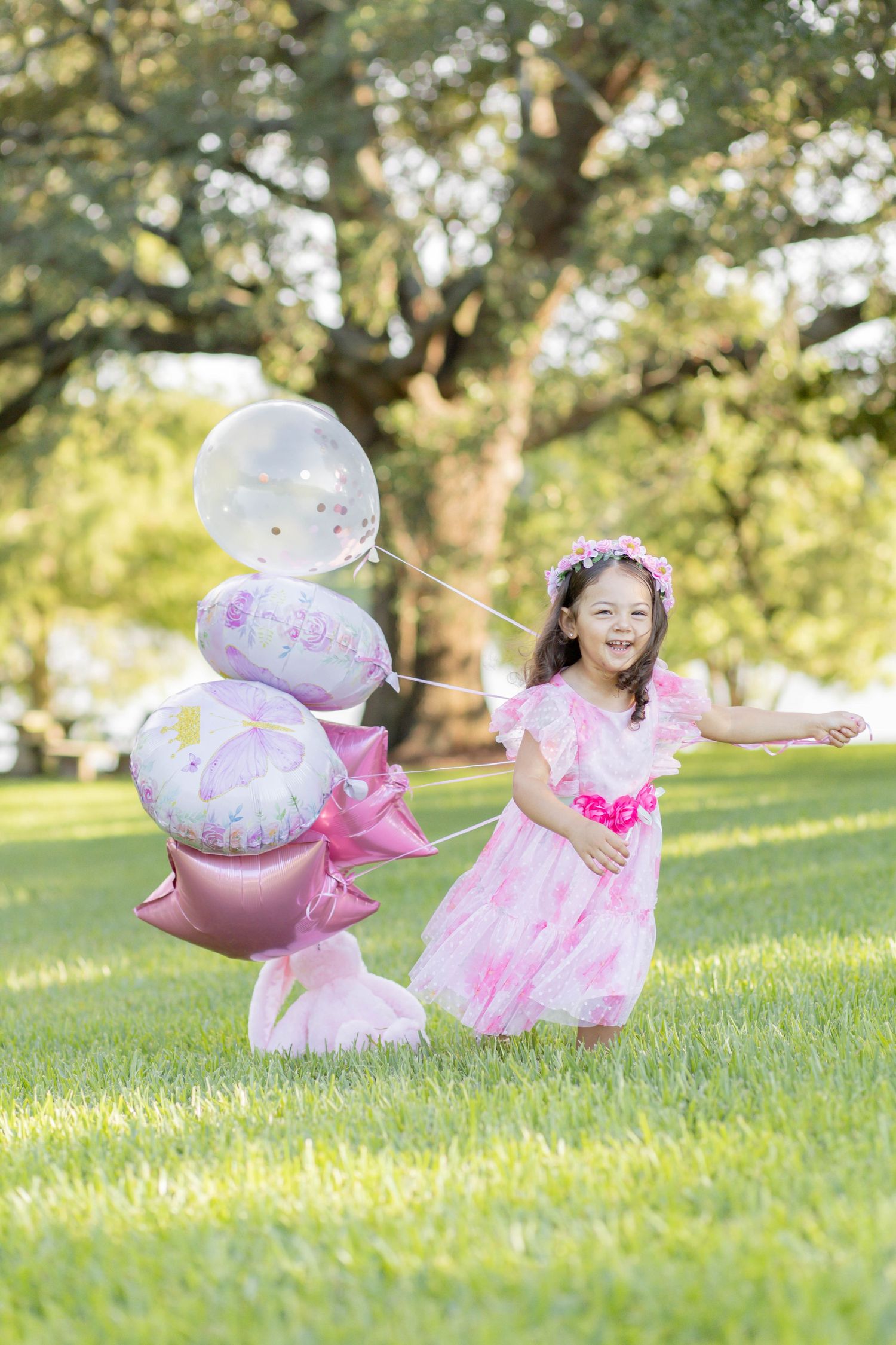 Joyful scene in a park with pink balloons and decorative elements on a sunny day.