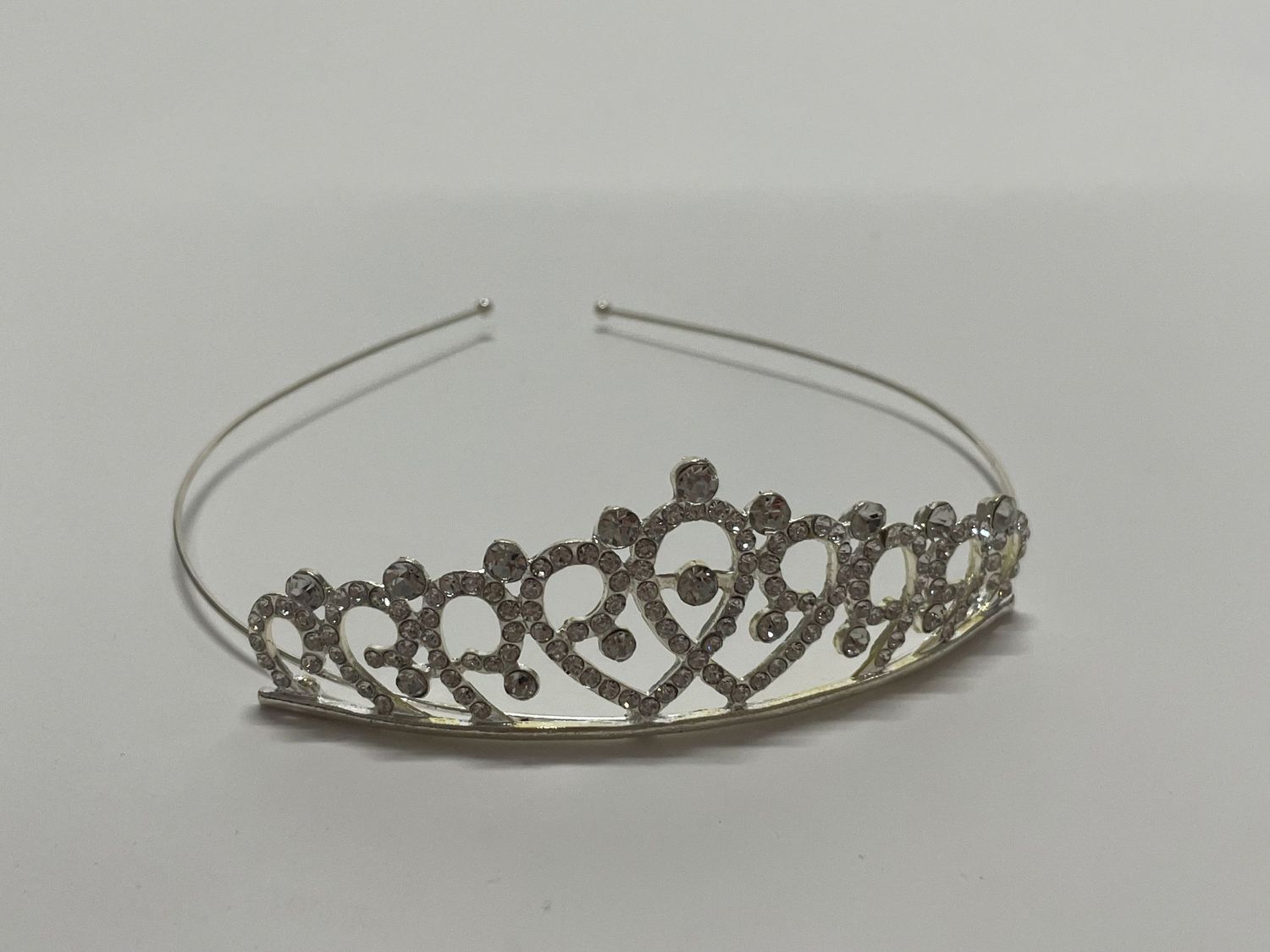 Silver plated tiara with rhinestone accents arranged in a delicate scalloped pattern.