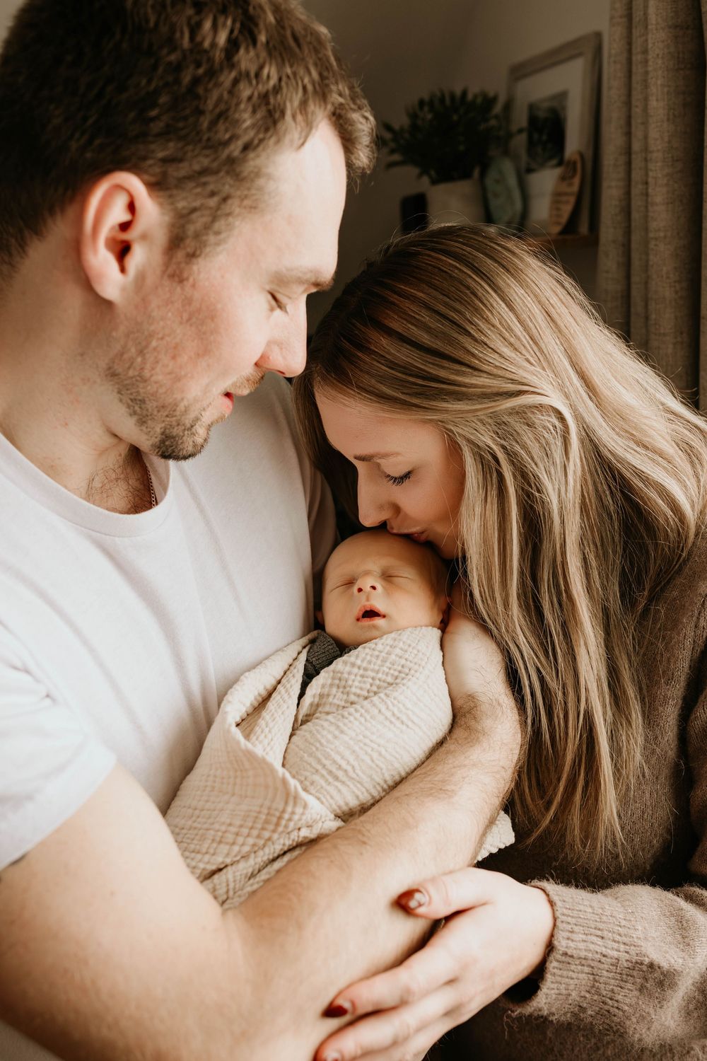 A tender family moment captured in warm tones showing intimate cuddles and closeness.