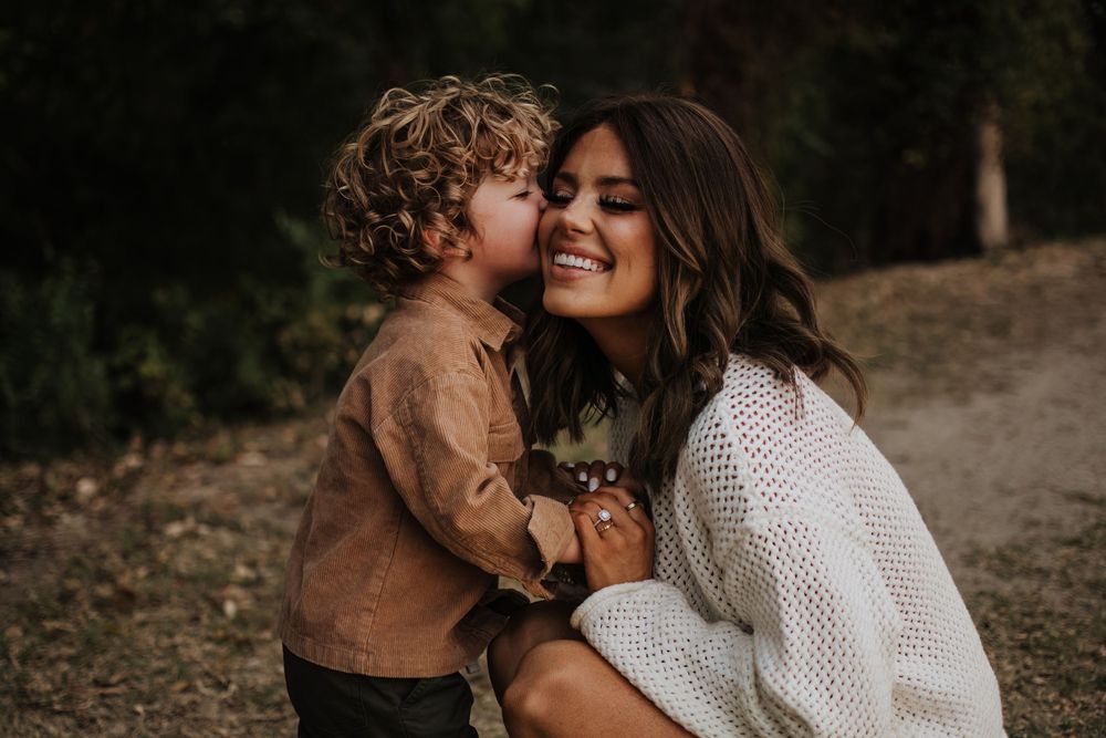 Intimate family moment captured during golden hour in nature setting. North Texas Family Photographer Alli Suzanne
