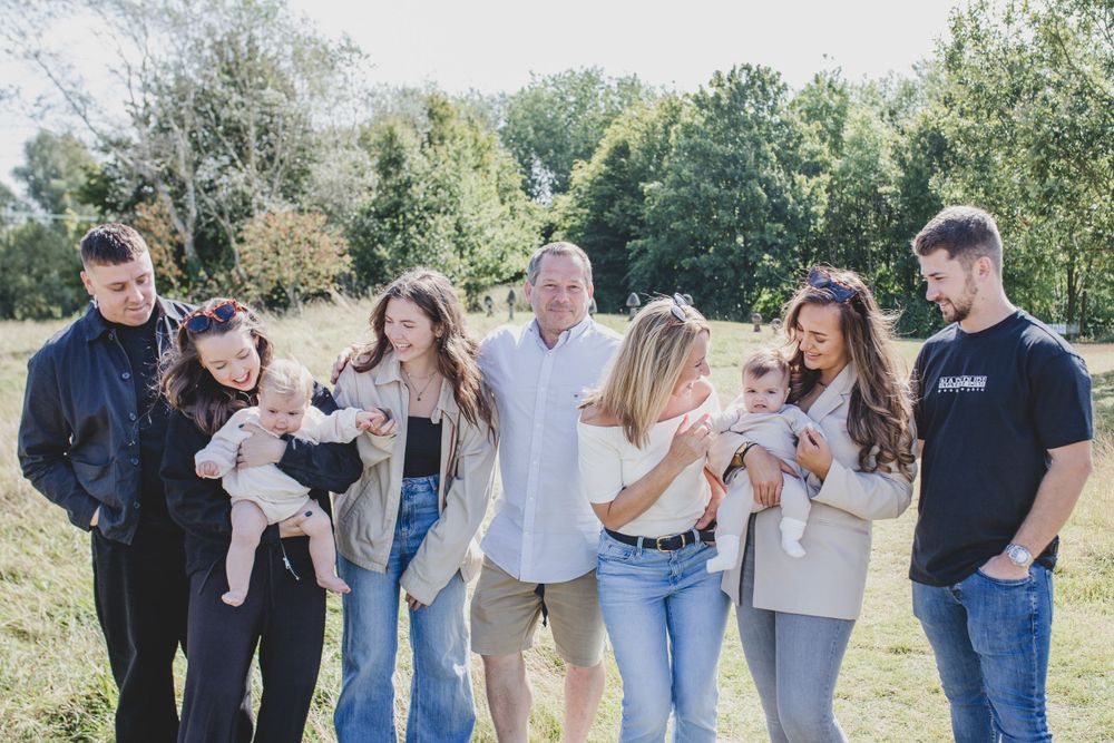 Extended Family group laughing together during outdoor photo session in sunny field.
Suffolk Family photos. Beckie Egan Photography.