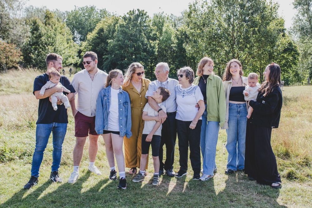 Large family group posing together outdoors in casual attire on sunny day.
Suffolk Family photos. Beckie Egan Photography.