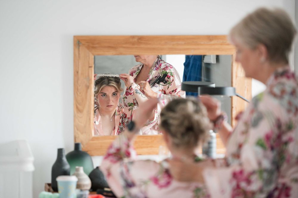 Getting ready in front of a bathroom mirror while wearing matching floral robes on special day.
