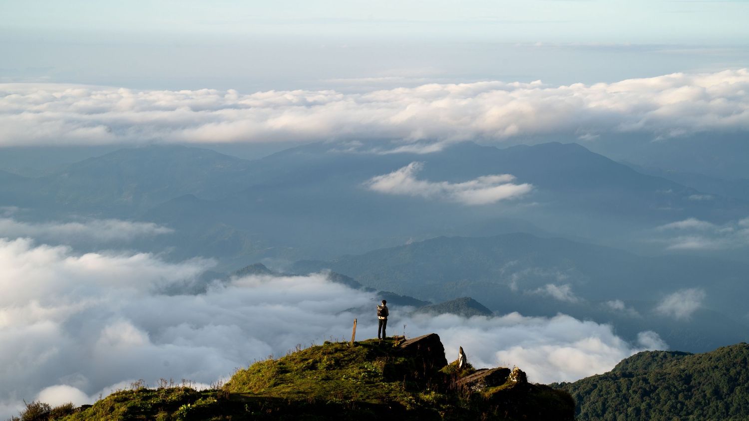 Dramatic mountain landscape with low-lying clouds rolling through the valley.