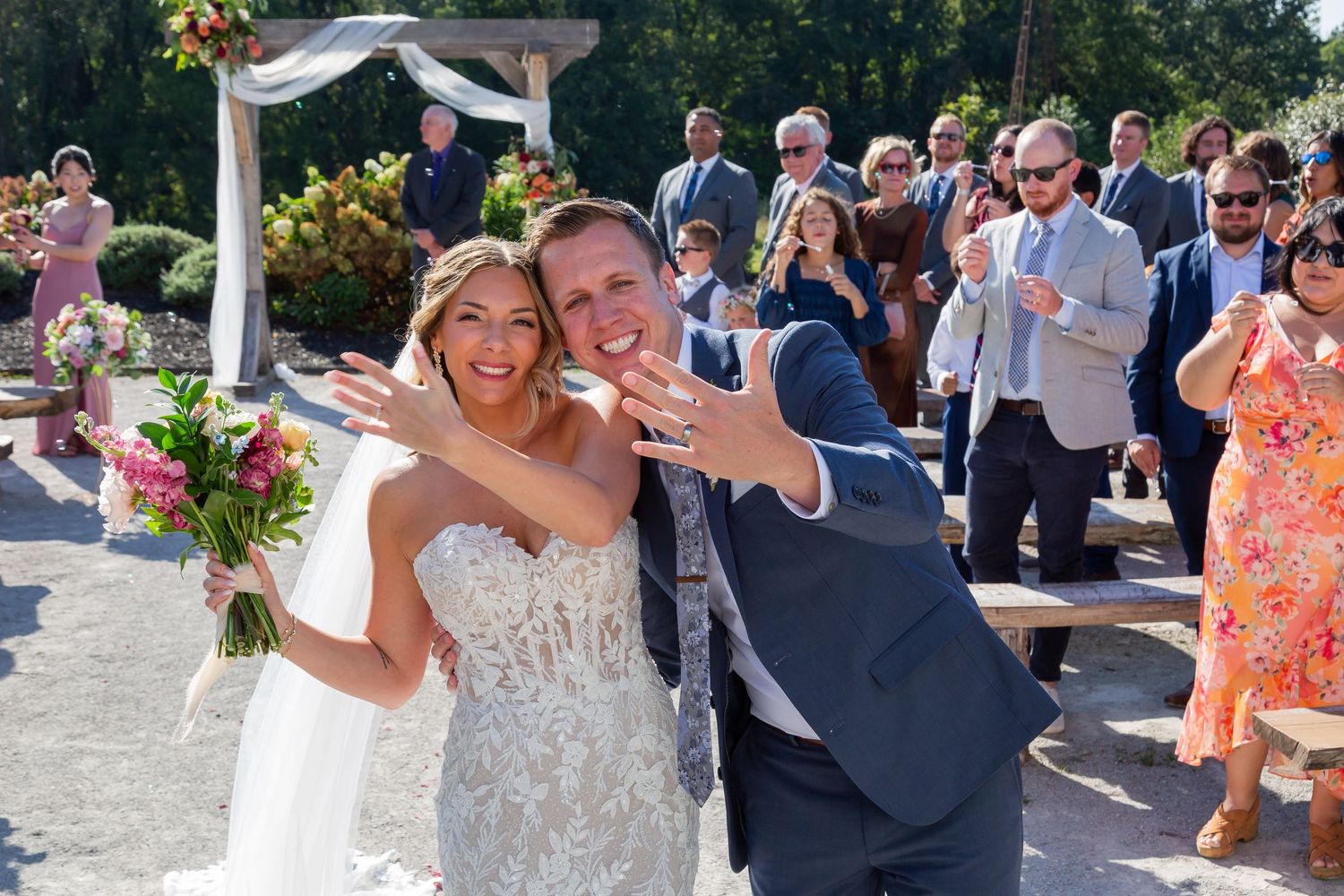 A bride and groom playfully share a bite of wedding cake together in black and white photograph.