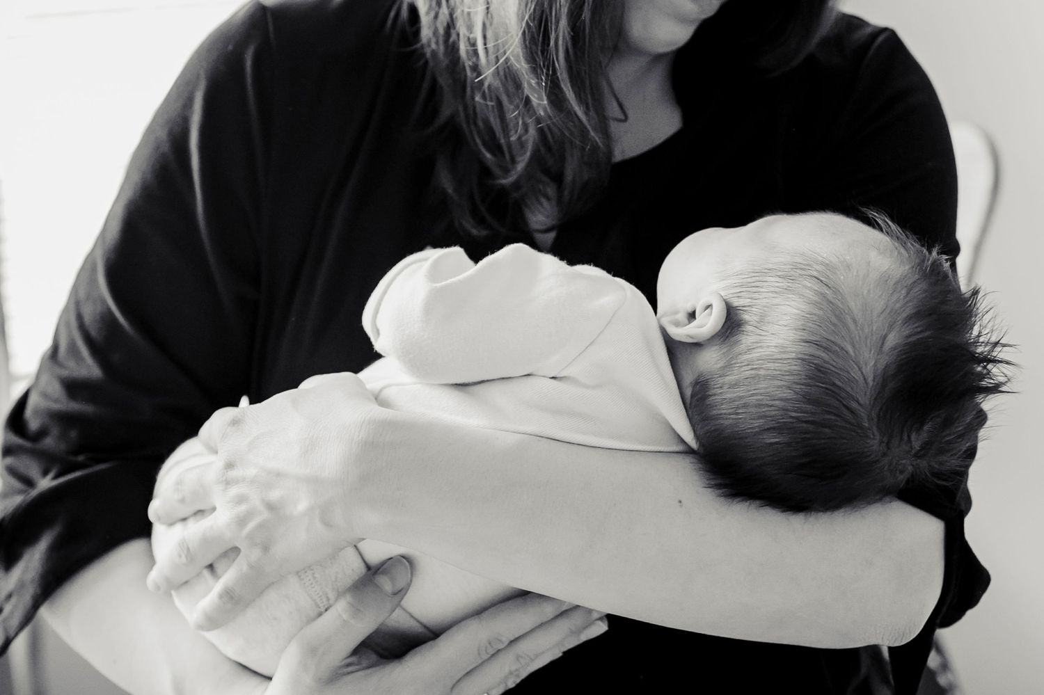 A heartwarming series of black and white images showing tender moments between parents and newborn babies.