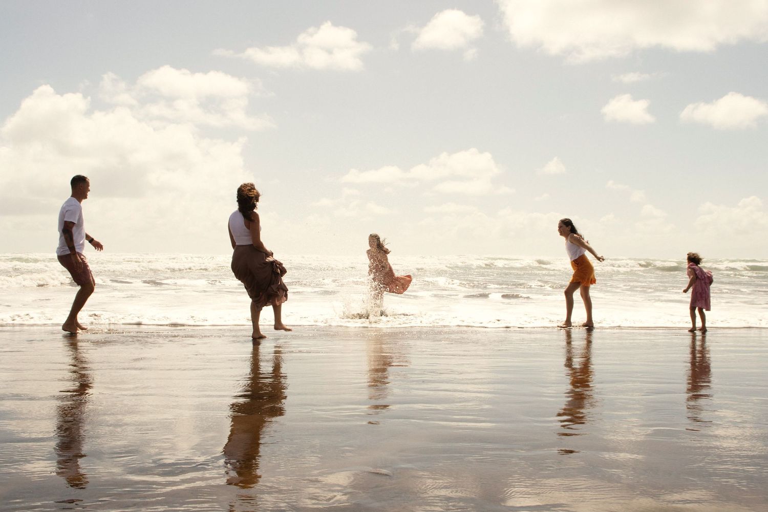 Family at the beach splashing each other with water