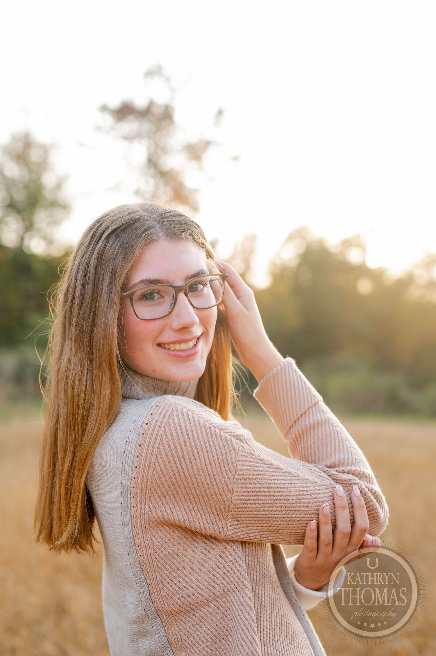 Warm sunset portrait with natural smile and cozy turtleneck sweater combination.