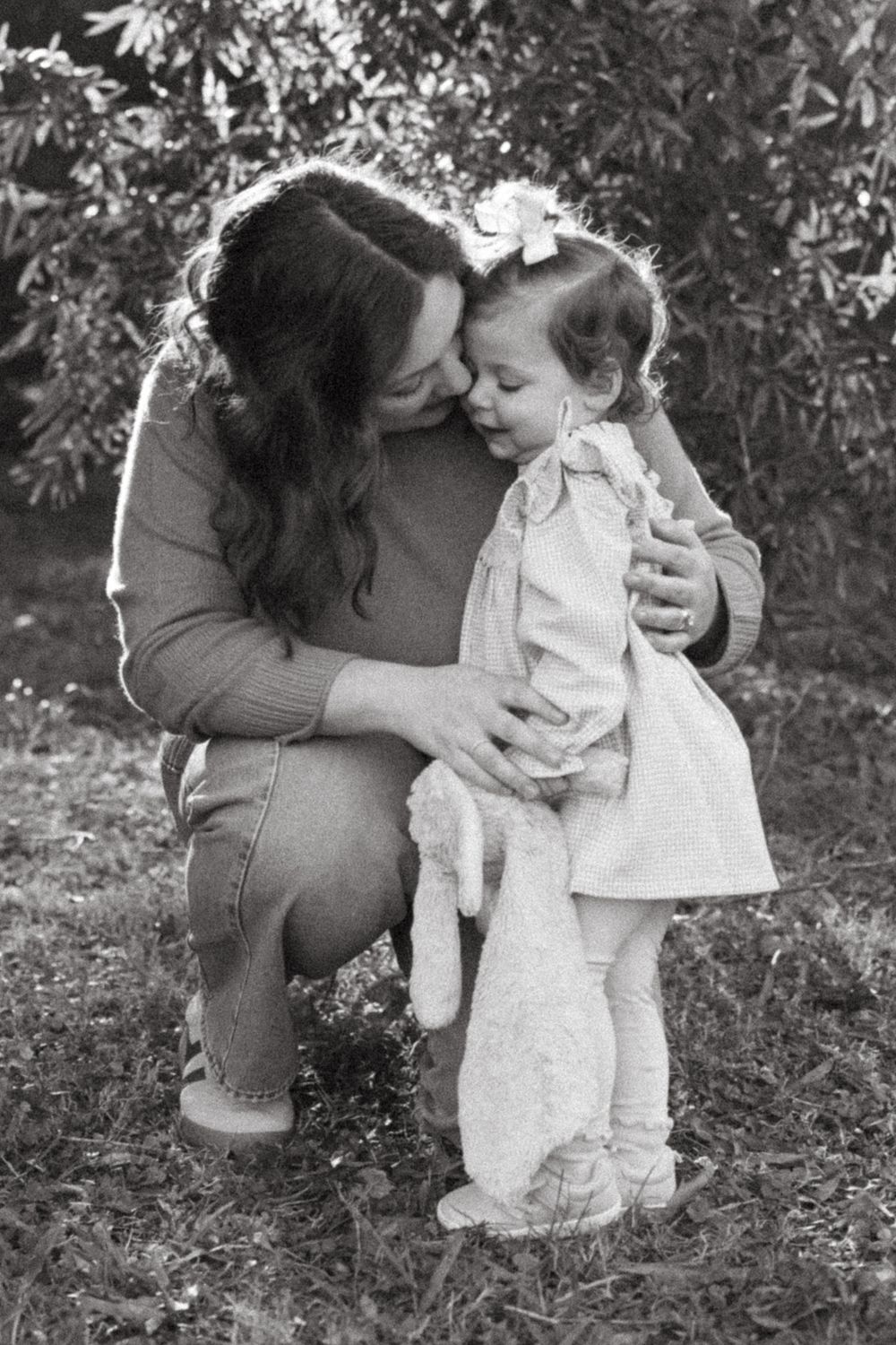 Black and white photo sequence showing tender interaction between parent and baby in white dress outdoors.