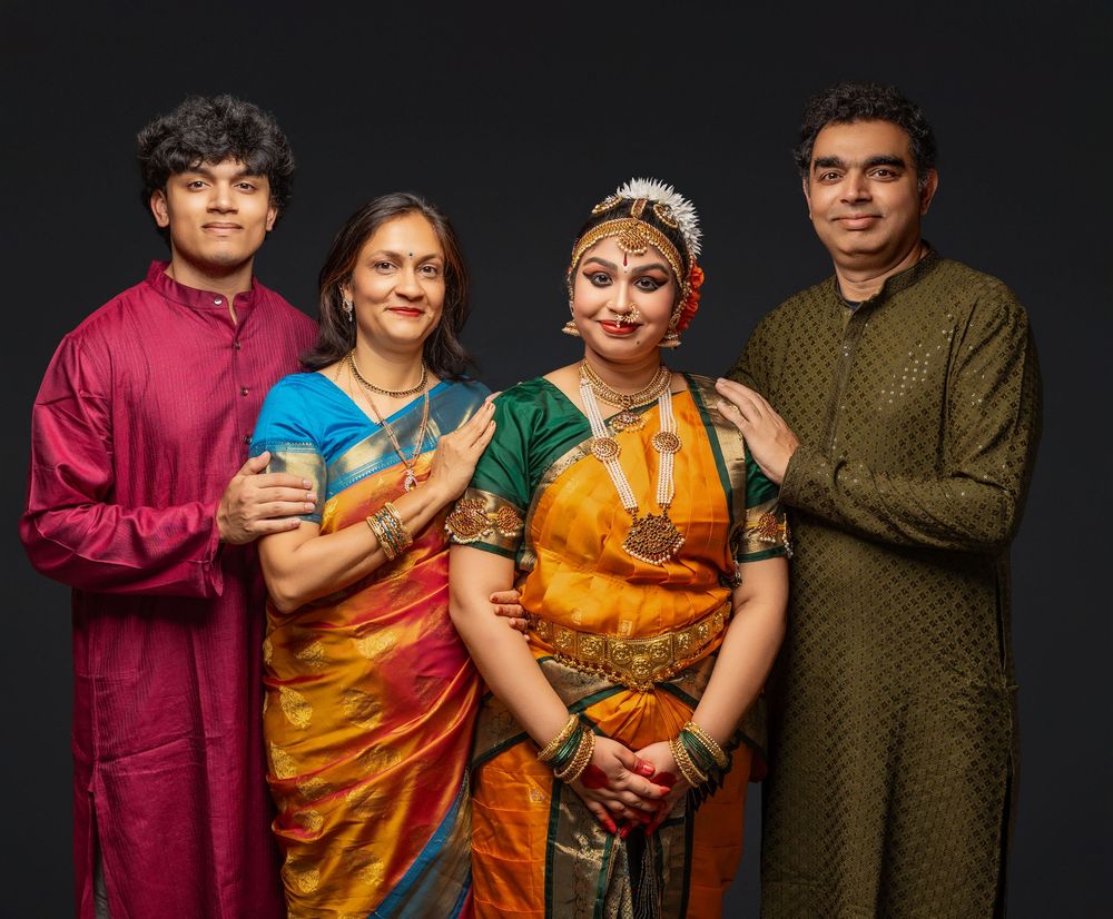 A group in traditional Indian attire poses together against a dark backdrop in a series of connected portrait photos.