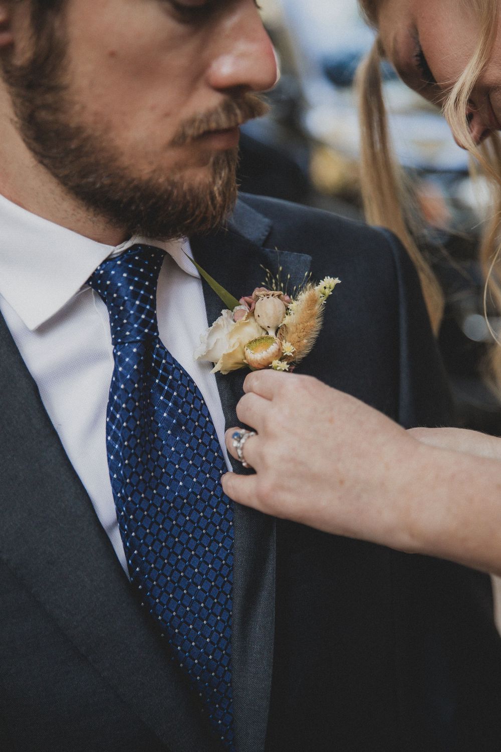 Close-up of someone in a navy blue tie and suit jacket eating during a formal event.