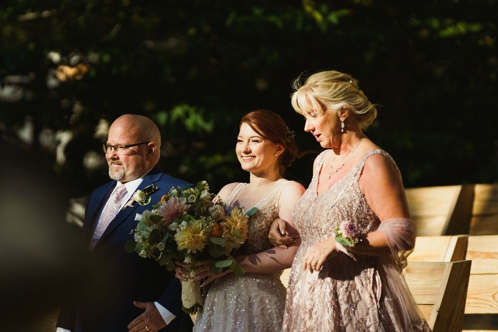 Wedding party standing together during outdoor ceremony with natural lighting.
