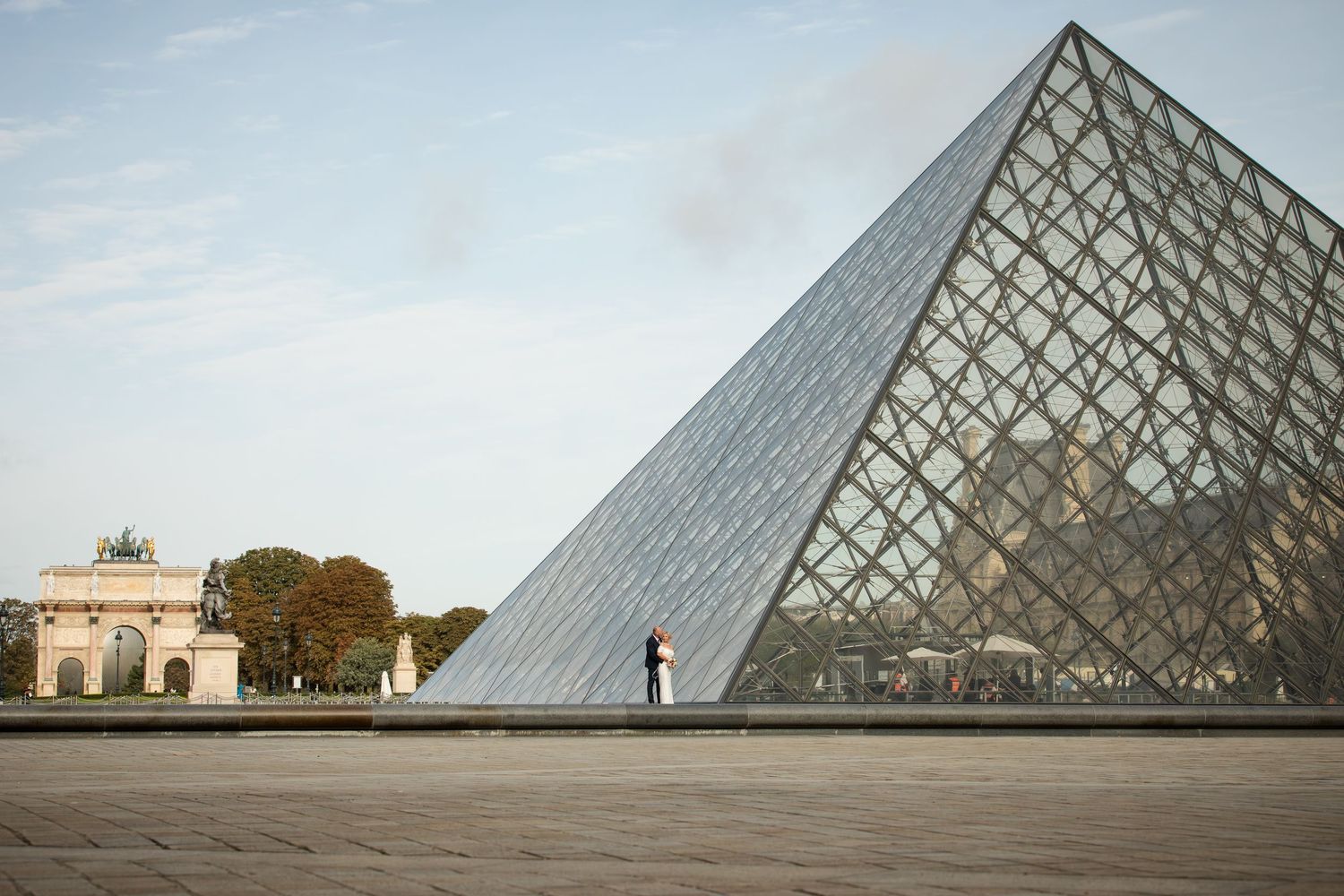 Louvre wedding elopement in Paris by Julien LB. High-end directed artistry and epic cinematic sunrise photo at the iconic glass pyramid
