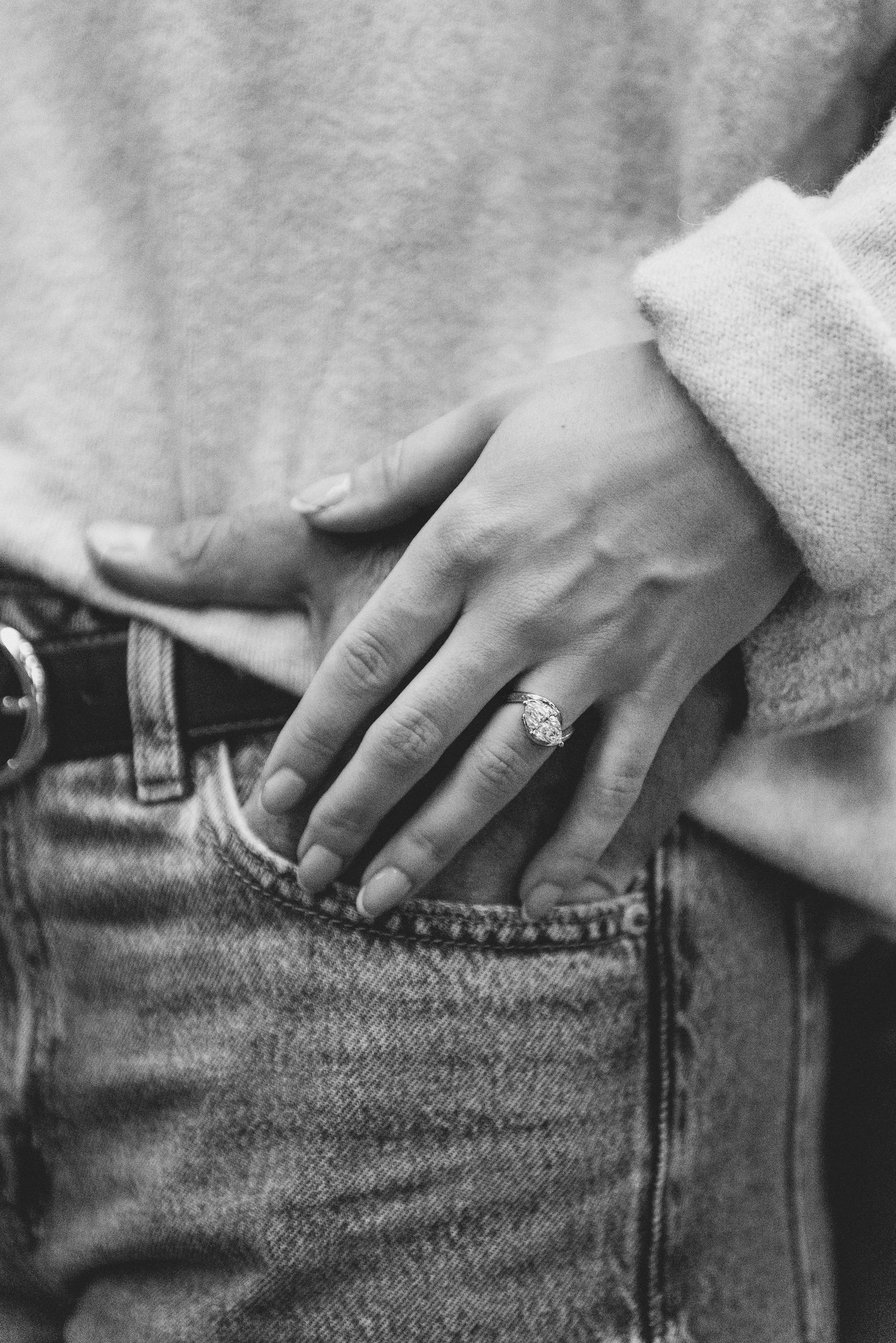 Close-up sequence of hands putting an engagement ring into a denim jeans pocket.