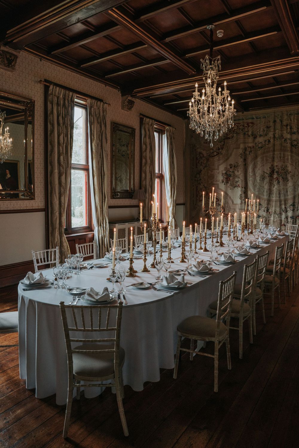 Elegant wedding reception table styling with brass candlesticks and white linen at Huntsham Court