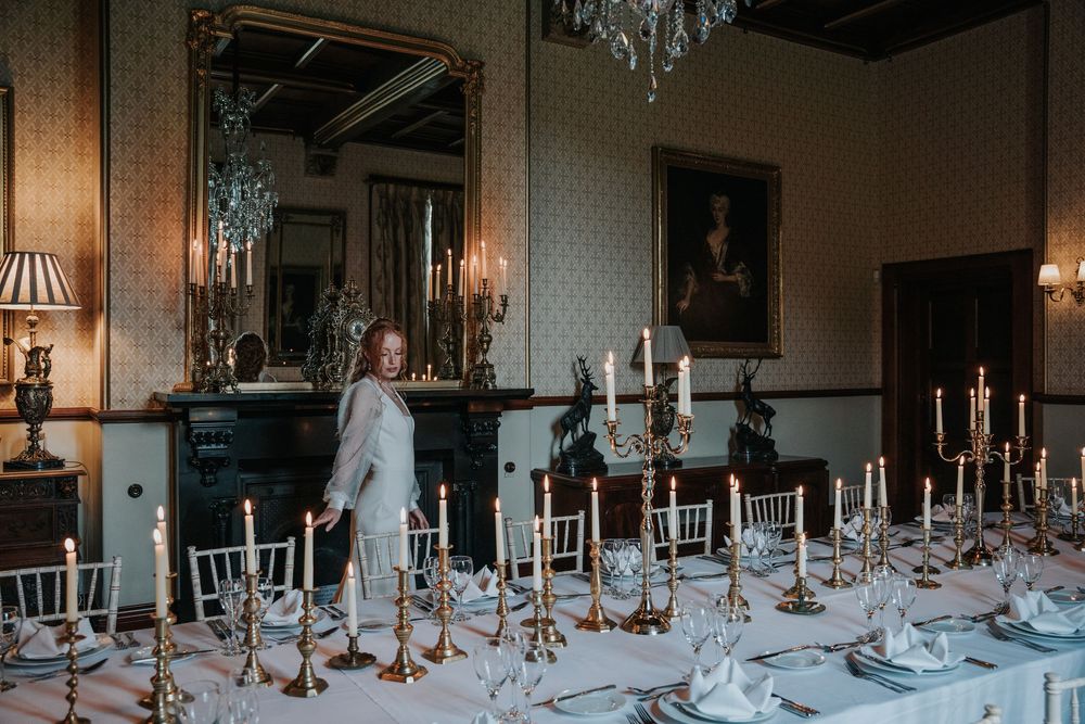 Elegant wedding reception table styling with brass candlesticks and white linen at Huntsham Court
