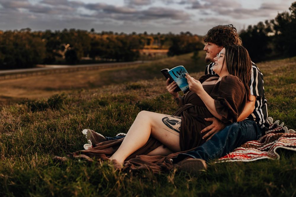 People enjoy a relaxing sunset picnic on a blanket in a grassy meadow with warm autumn lighting.