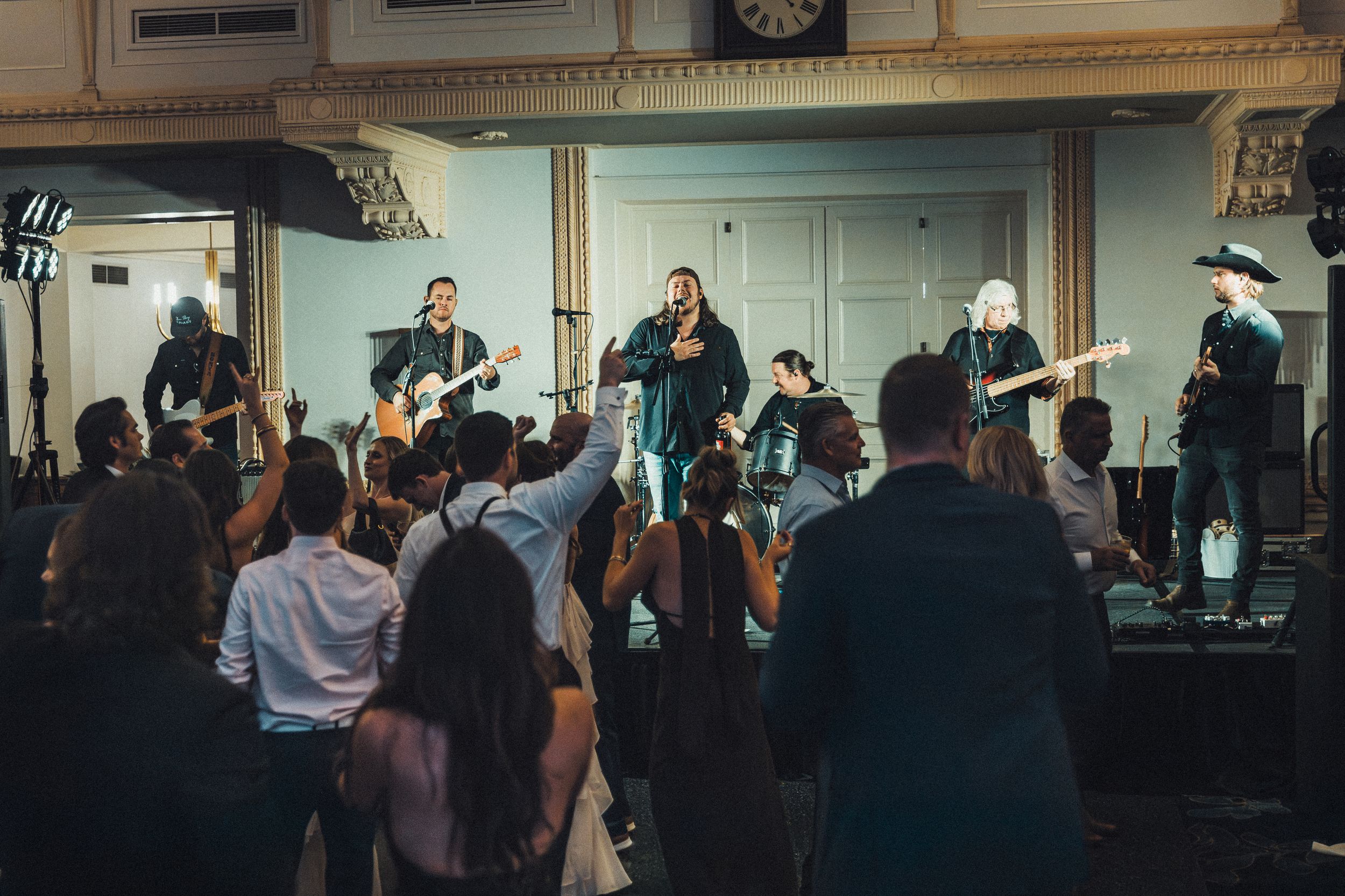 Live band performing on stage at a wedding reception with crowd dancing below. live event photography st louis