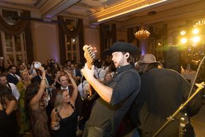 Musicians performing for an energetic crowd at an elegant venue with ornate lighting. live event photography st louis