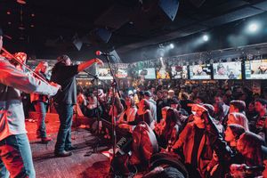 Crowd enjoying a concert with red lighting effects in a packed venue. live event photography st louis