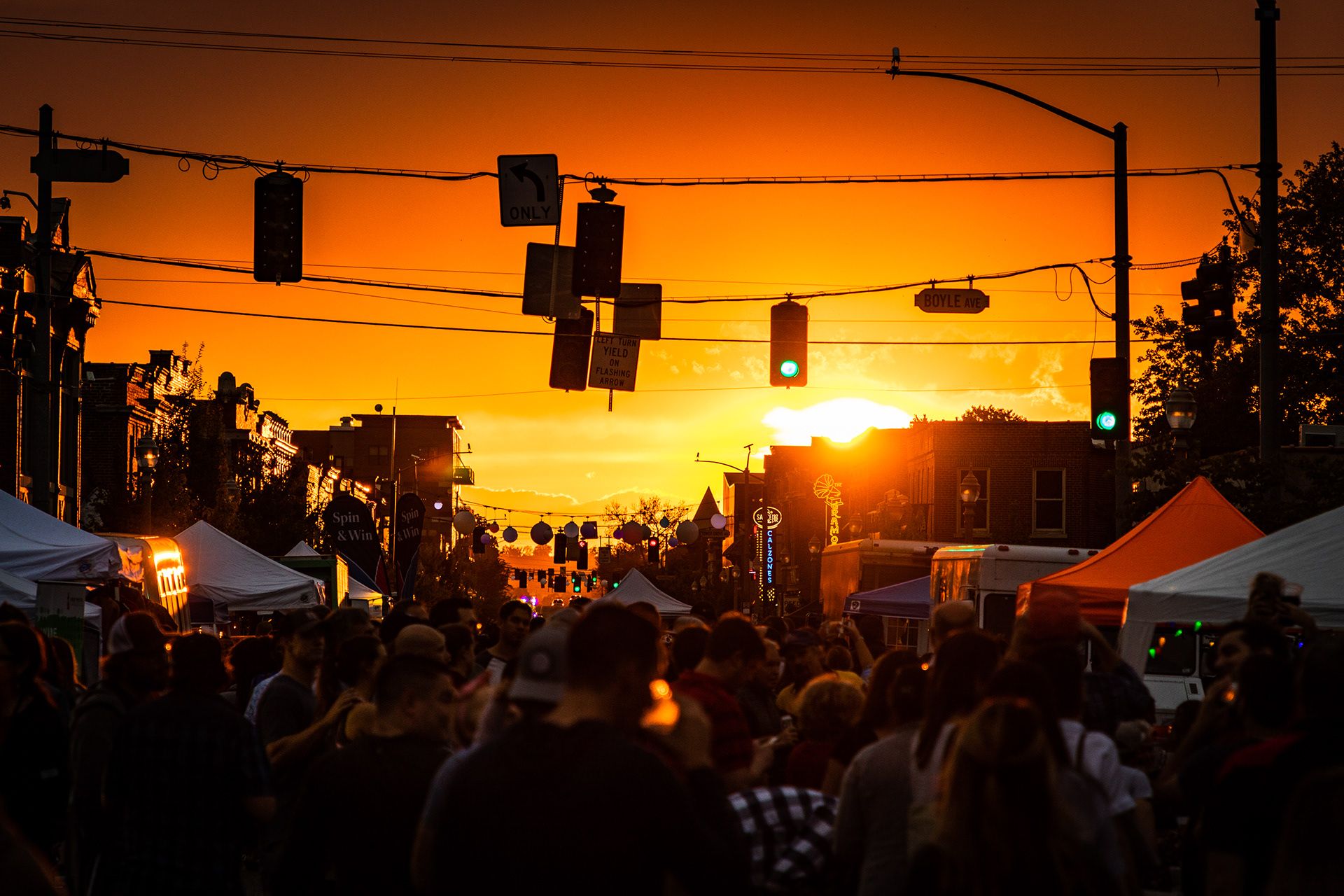 Dramatic orange sunset silhouetting traffic lights and palm trees against an urban skyline. live event photography st louis.