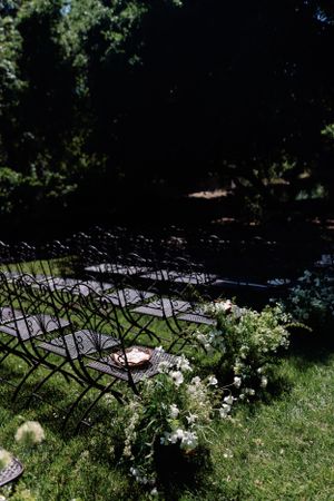 Outdoor wedding ceremony setup with rows of chairs and floral decorations.