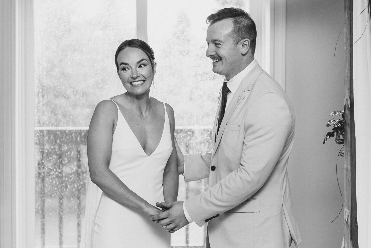 A black and white photo collage showing joyful wedding moments between a couple in formal attire.