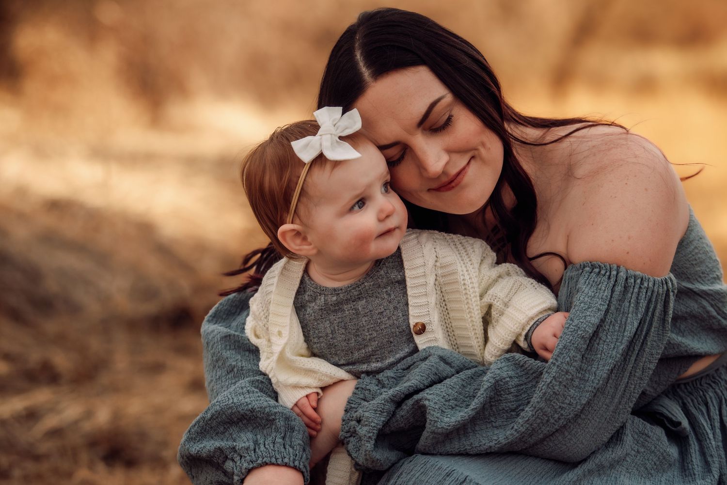 A tender family moment captured in warm golden light during an outdoor photo session.