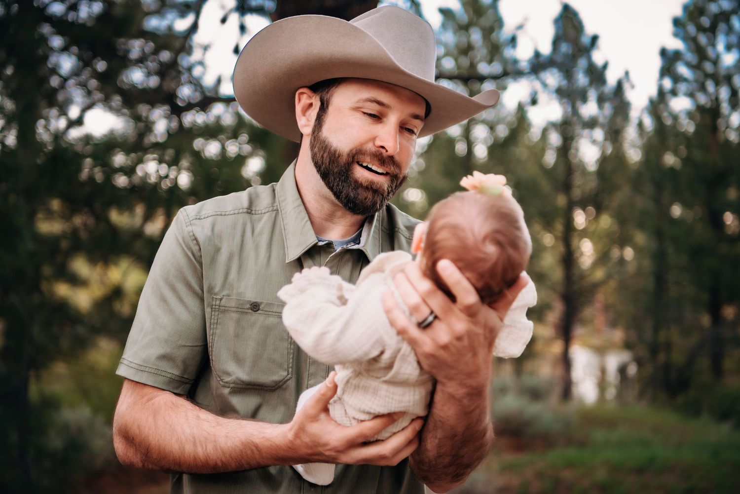 Candid family moment outdoors with rustic backdrop.