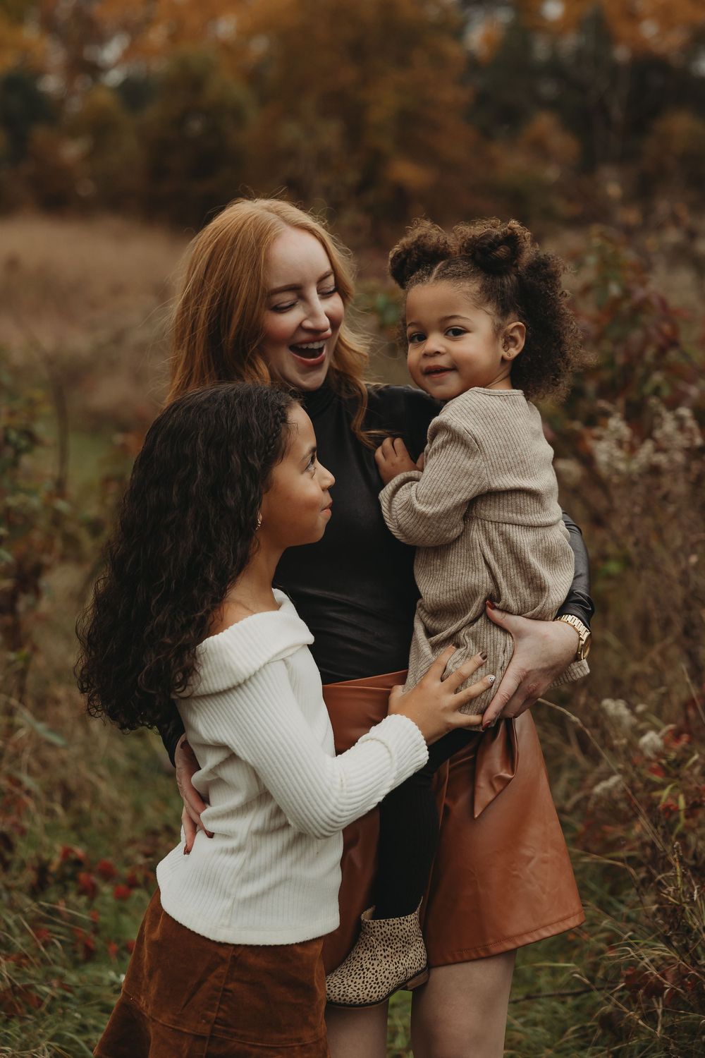 Parent and child share joyful moments together outdoors during autumn while wearing cozy sweaters.