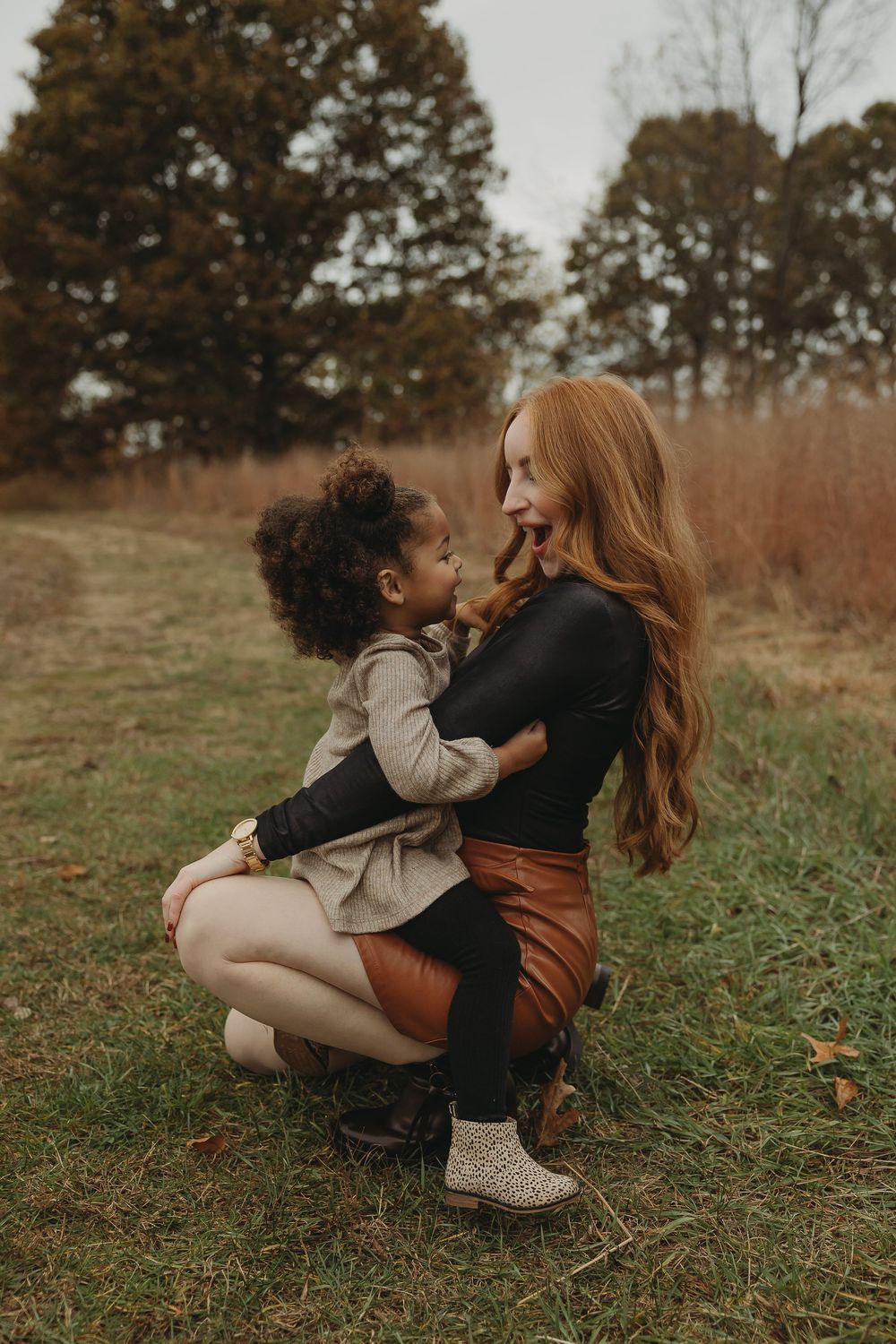 A tender moment captured between two people embracing on autumn grass in a natural outdoor setting.