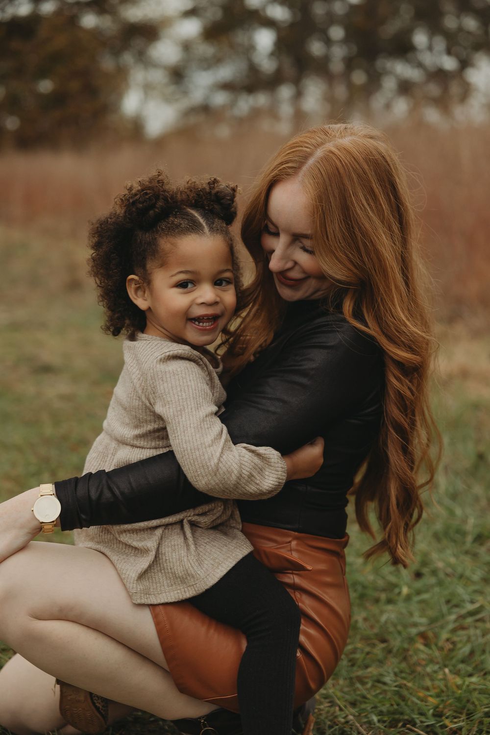 A tender moment captured outdoors showing joyful interaction between parent and child on an autumn day.