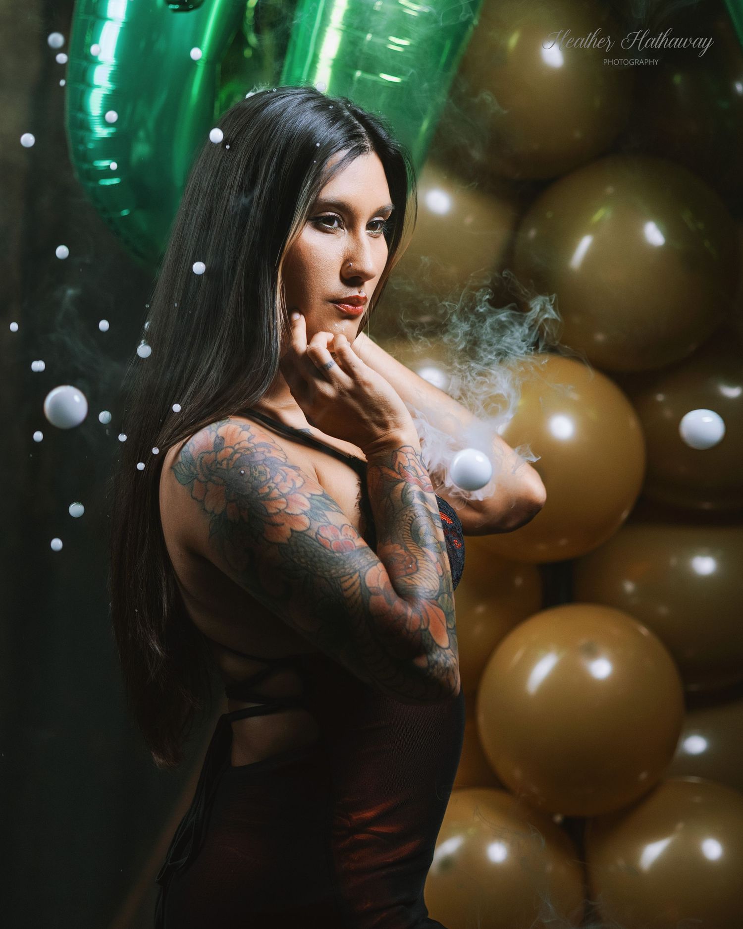 Atmospheric portrait with dramatic lighting against green and gold balloons in a dark moody setting.