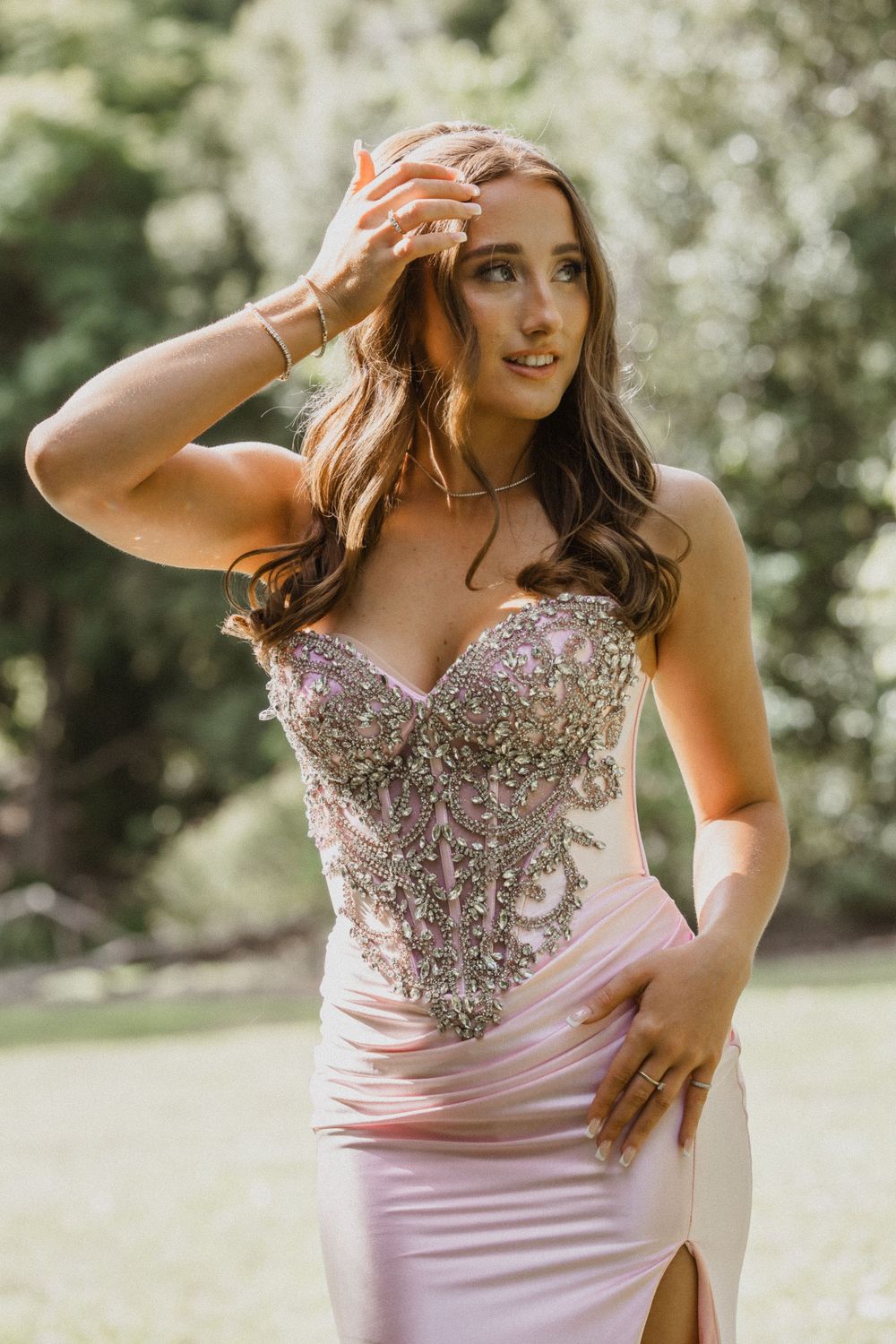 Formal/Graduation session young woman in elegant strapless pink and silver gown posing for photos at an outdoors location in Caboolture.