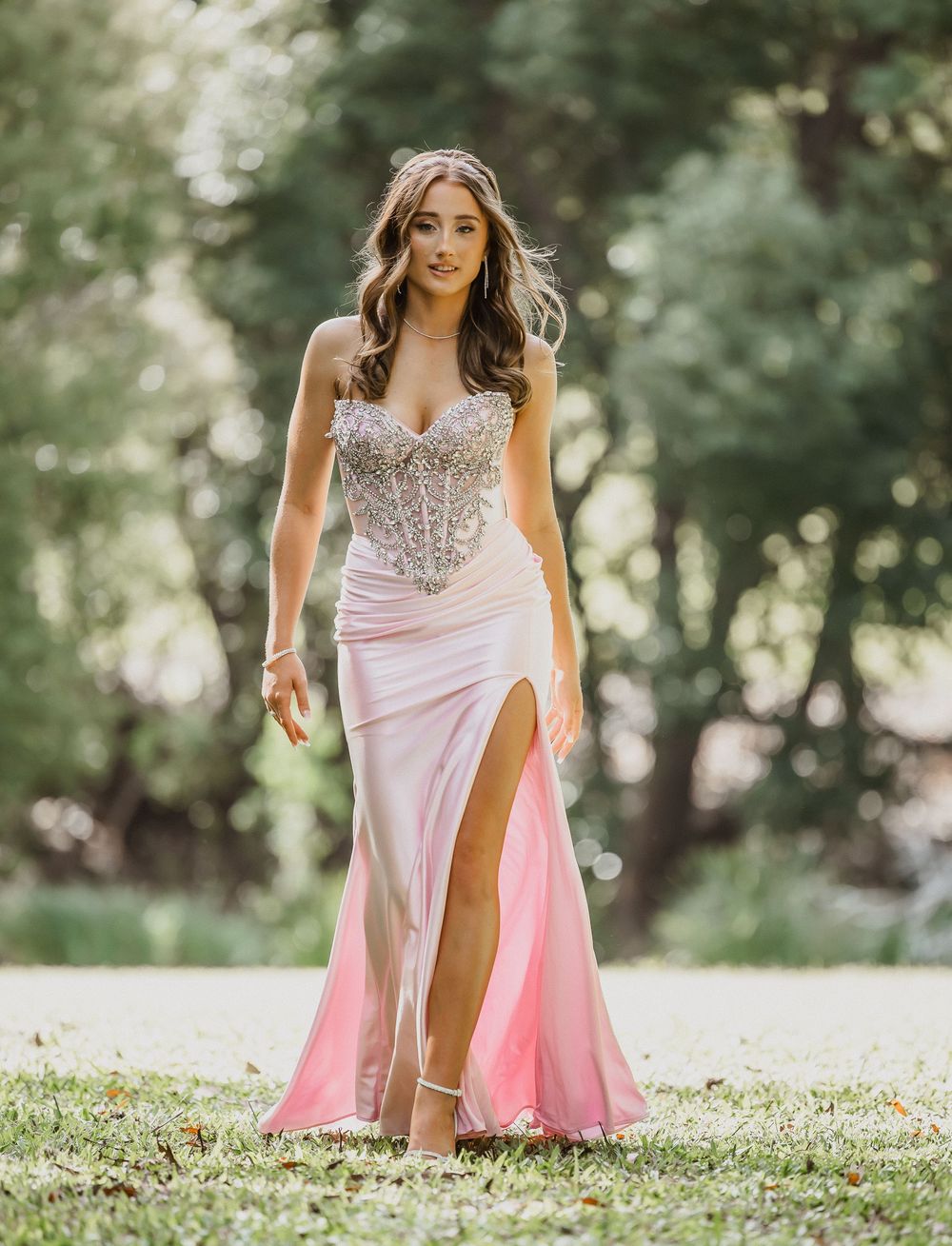Formal/Graduation session young woman in elegant strapless pink and silver gown posing for photos at an outdoors location in Caboolture.