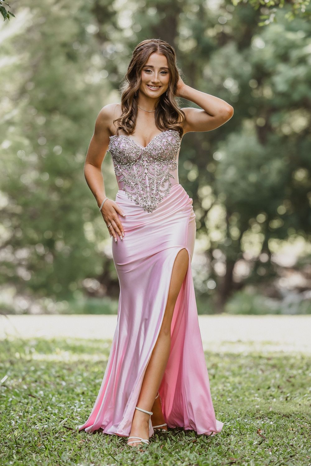 Formal/Graduation session young woman in elegant strapless pink and silver gown posing for photos at an outdoors location in Caboolture.