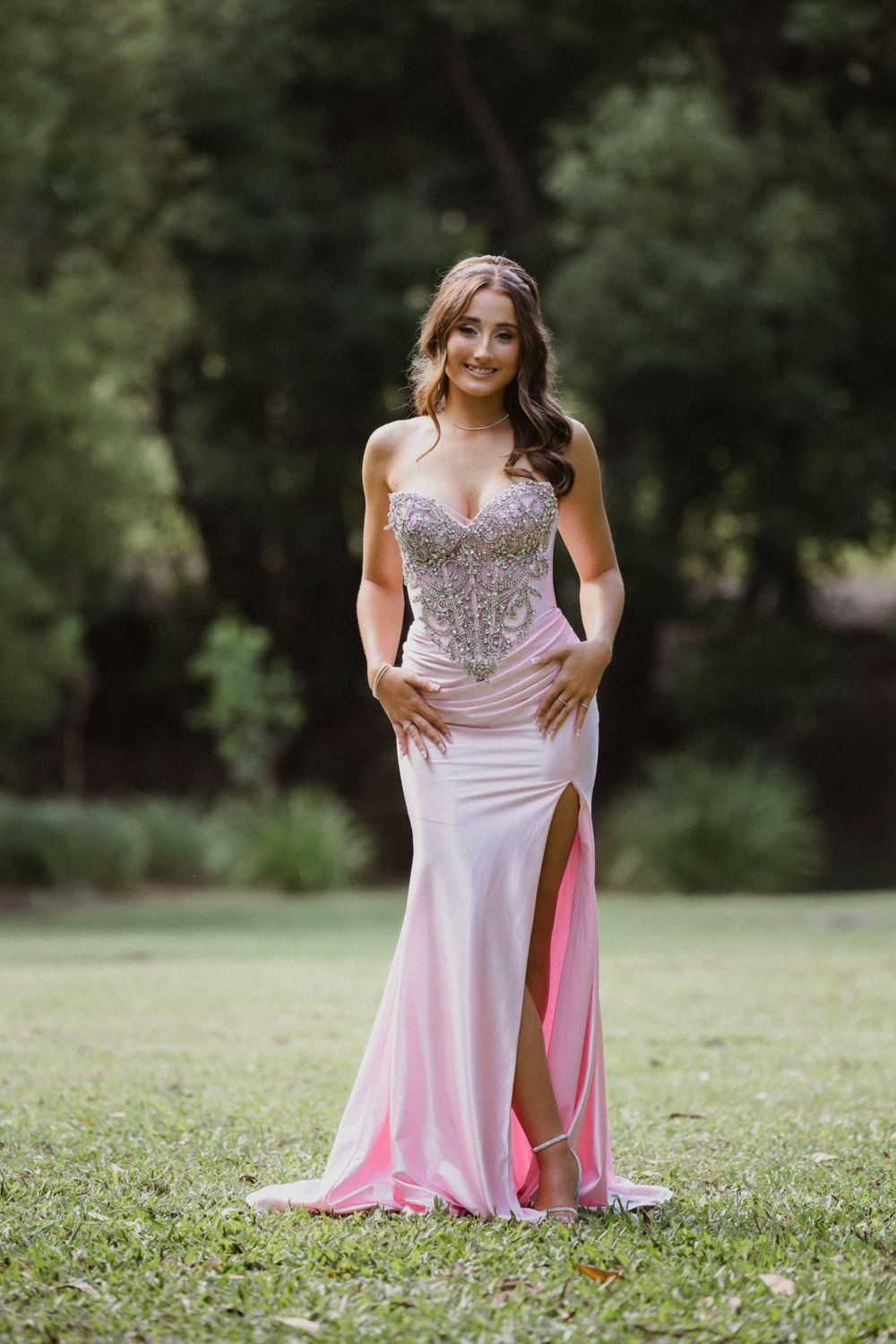 Formal/Graduation session young woman in elegant strapless pink and silver gown posing for photos at an outdoors location in Caboolture.