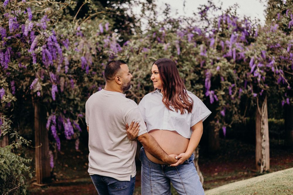 Purple wisteria blooms hang overhead in a dreamy garden setting creating a romantic atmosphere.