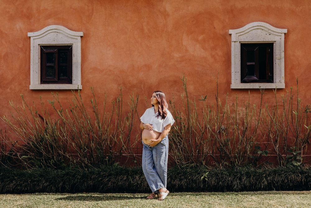 A sequence of five connected photos showing a figure dancing against a rustic orange wall with small windows.