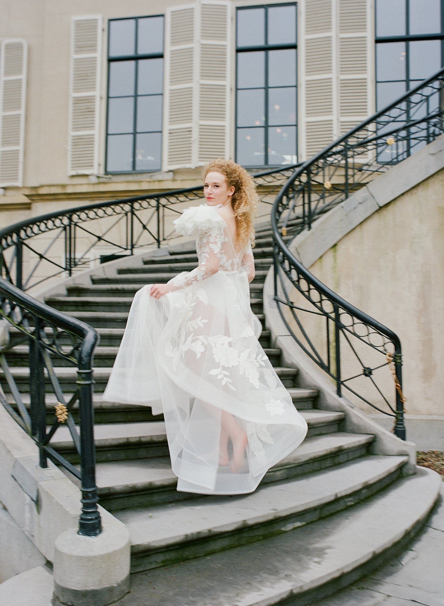 A sequence of photos showing a bride in a white dress gracefully moving down elegant stone steps with wrought iron railings.