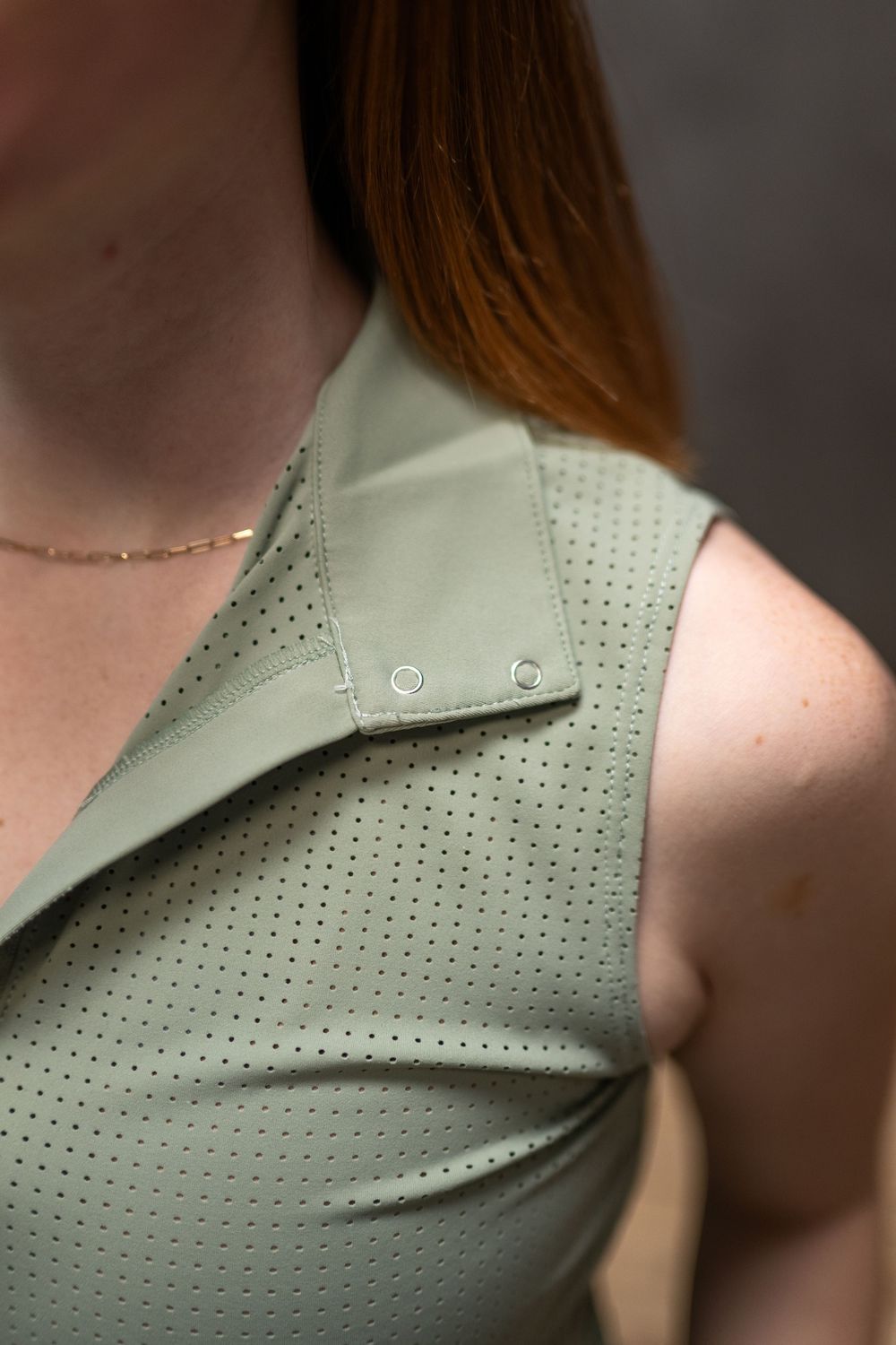 Close-up detail of perforated gray leather upholstery with stitching pattern.