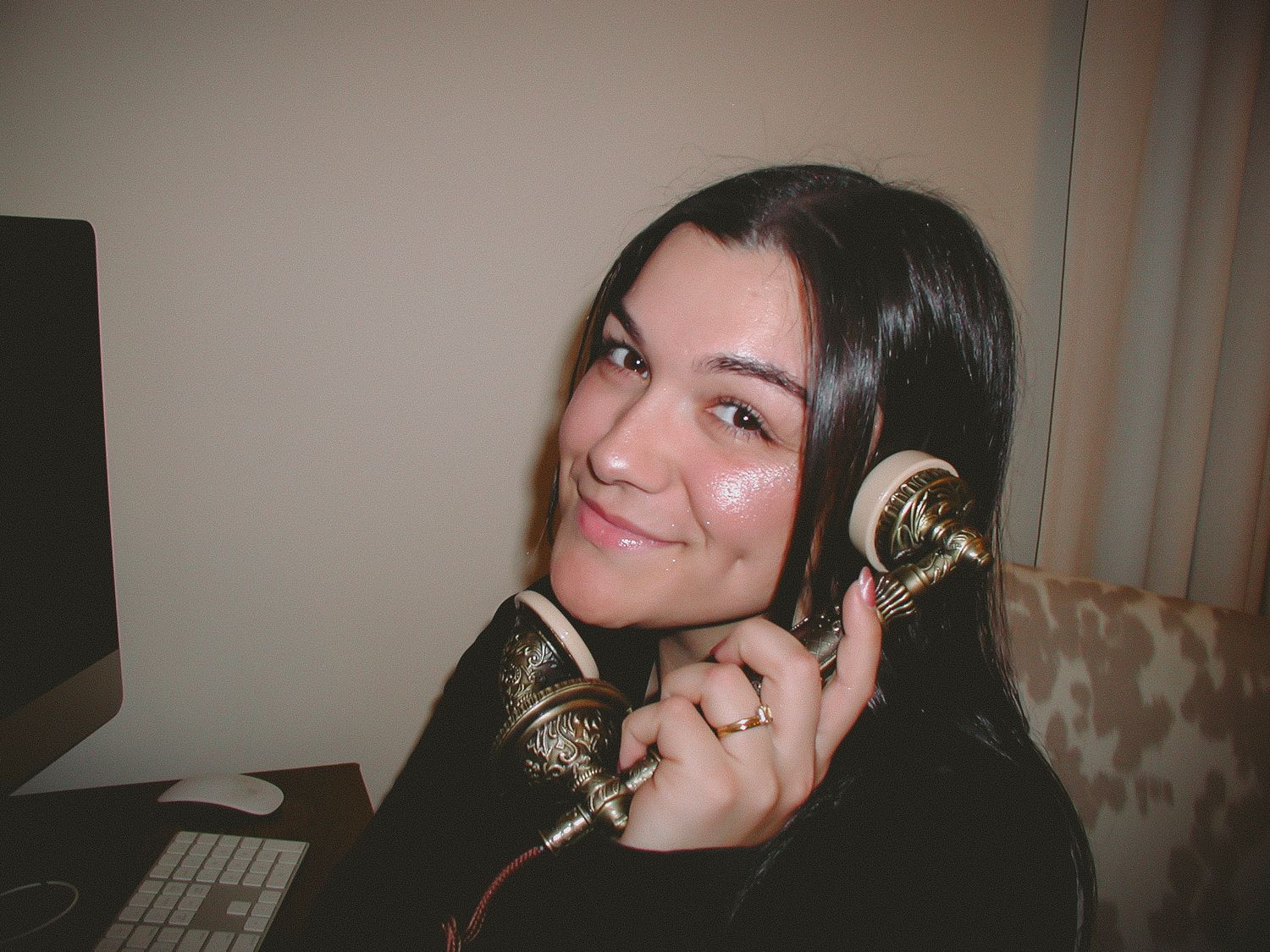 A person with dark hair smiles while wearing headphones in a series of four similar photos.