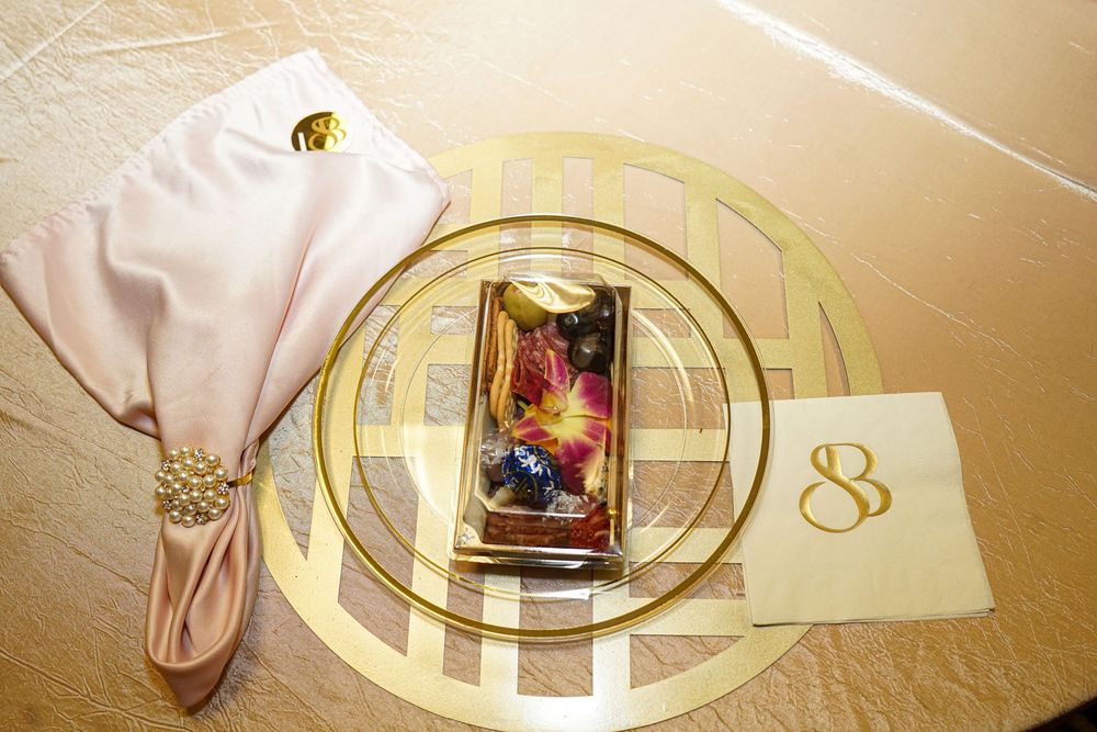 Elegant place settings with gold charger plates and white napkins arranged on a formal dining table.