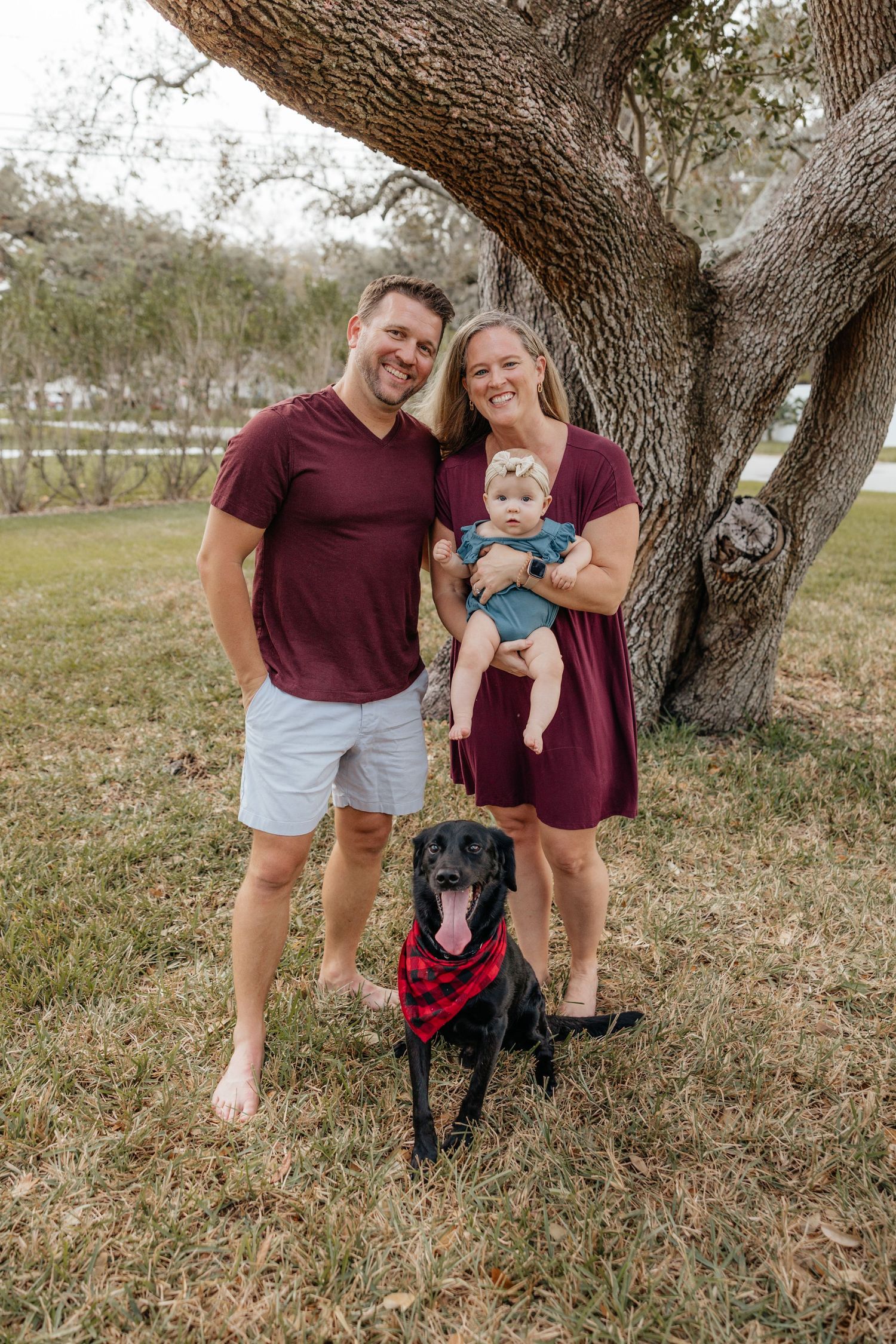 Family standing together under a tree during a family photography session.