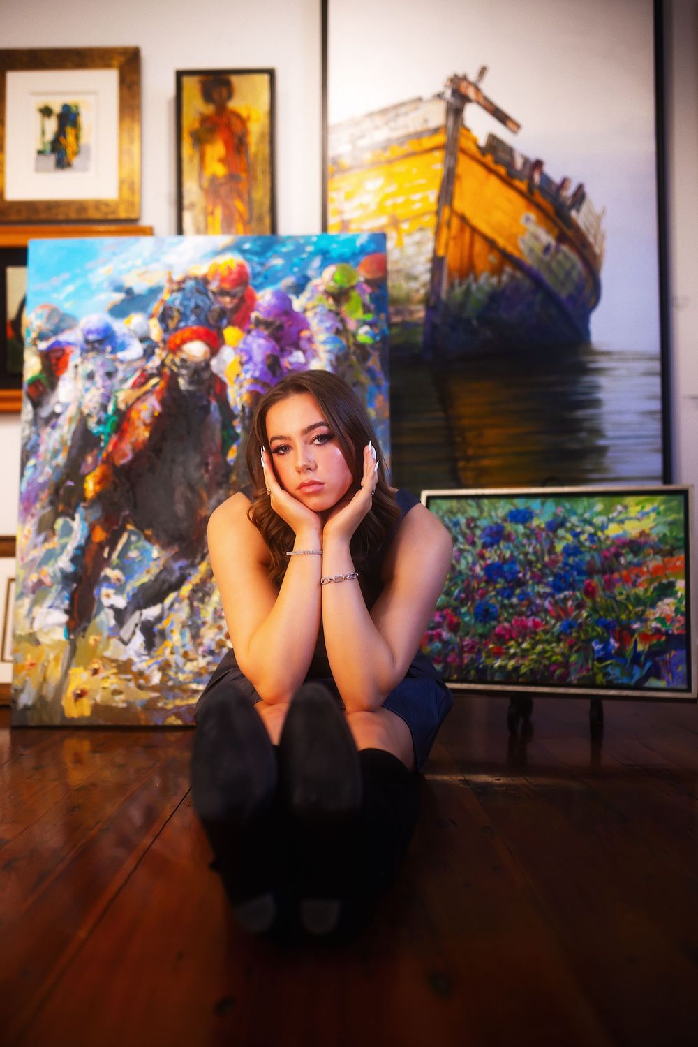 A series of artistic portraits displayed in a gallery showing a person posing against colorful floral backgrounds.