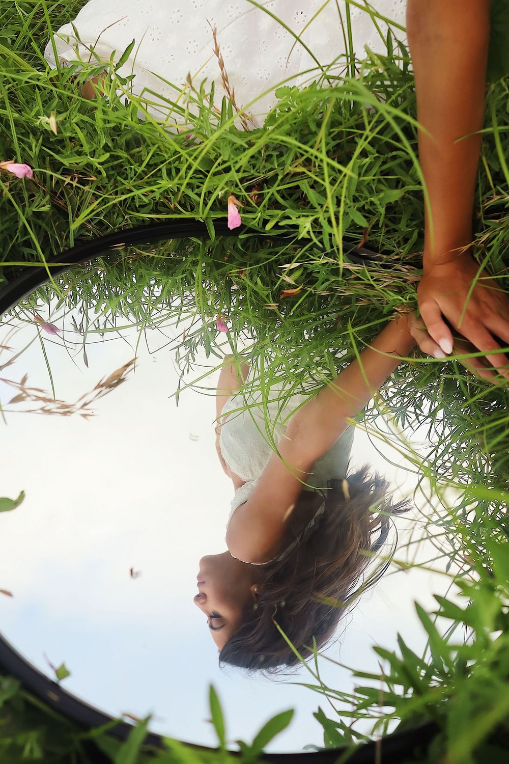 Minimalist photo series showing bare feet against a white background surrounded by green grass blades.