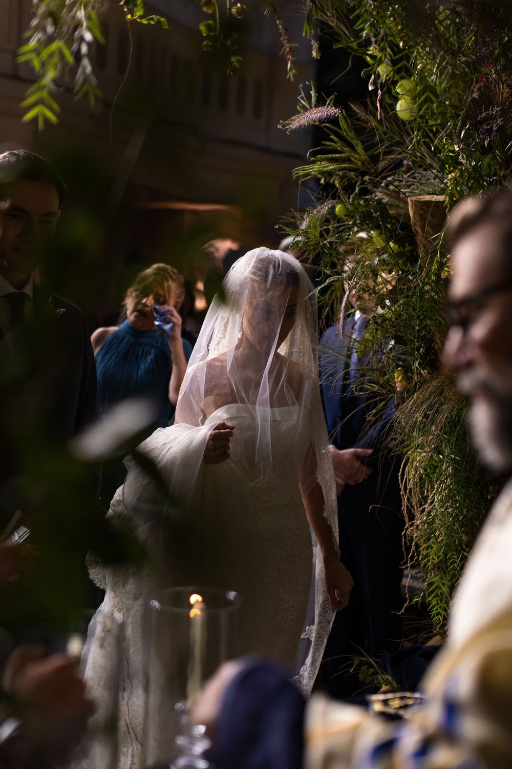Wedding reception setup with greenery decorations and soft lighting creating an intimate atmosphere.
