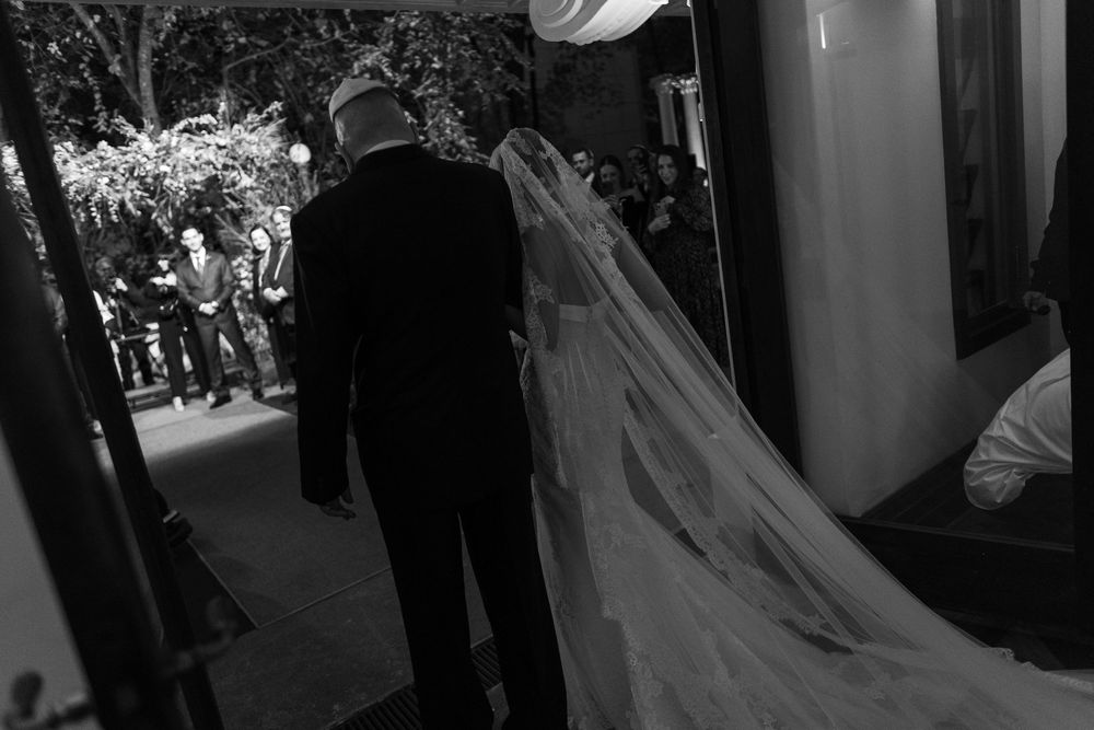 Bride and groom share a tender moment during their first dance at an elegant wedding reception.