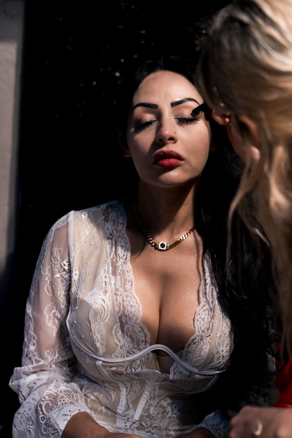 Artistic portrait series of a woman in white lace lingerie with dramatic lighting against dark background.